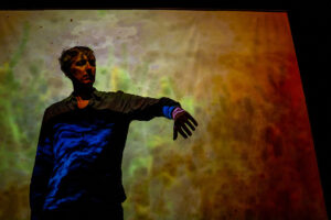 lars dammark in front of projections in the performance my sister is a mermaid