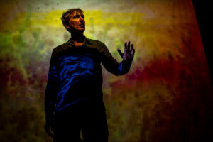 lars dammark in front of projections in the performance my sister is a mermaid