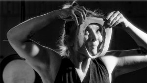 woman looking through an hole in a piece of clay