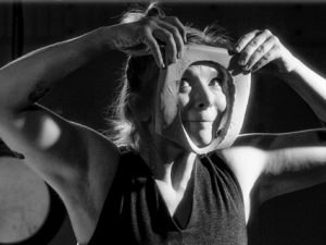 woman looking through an hole in a piece of clay