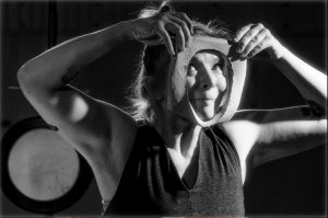 woman looking through an hole in a piece of clay