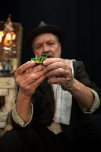 mand med hat holder legetøjsstraktor