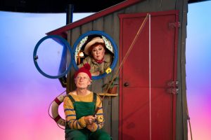 En mand og en kvinde med fiskestang og et lille træhus fra forestillingen flaskepost med riddersalen - gæstespil på teatret gruppe 38