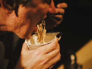 mand spiser nudler fra dåse