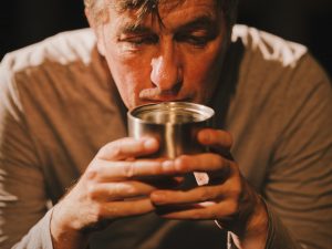 mand drikker af stålkop