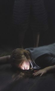 kvinde ligger på mørkt gulv på foto fra danseforestillingen The Labyrinth