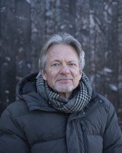 Niels Søren Hansen foran mørk baggrund i træmateriale