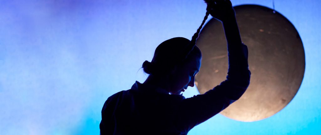 kvinde i profil hlder sin fletning så den ligner et reb til en galge_durita_den fremmede med teatret møllen hos teatret gruppe 38