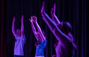 Er-vi-os_forstilling-med-sansevaerk-paa-teatret-gruppe-38_unge mennesker med maske på rækker armene i vejret